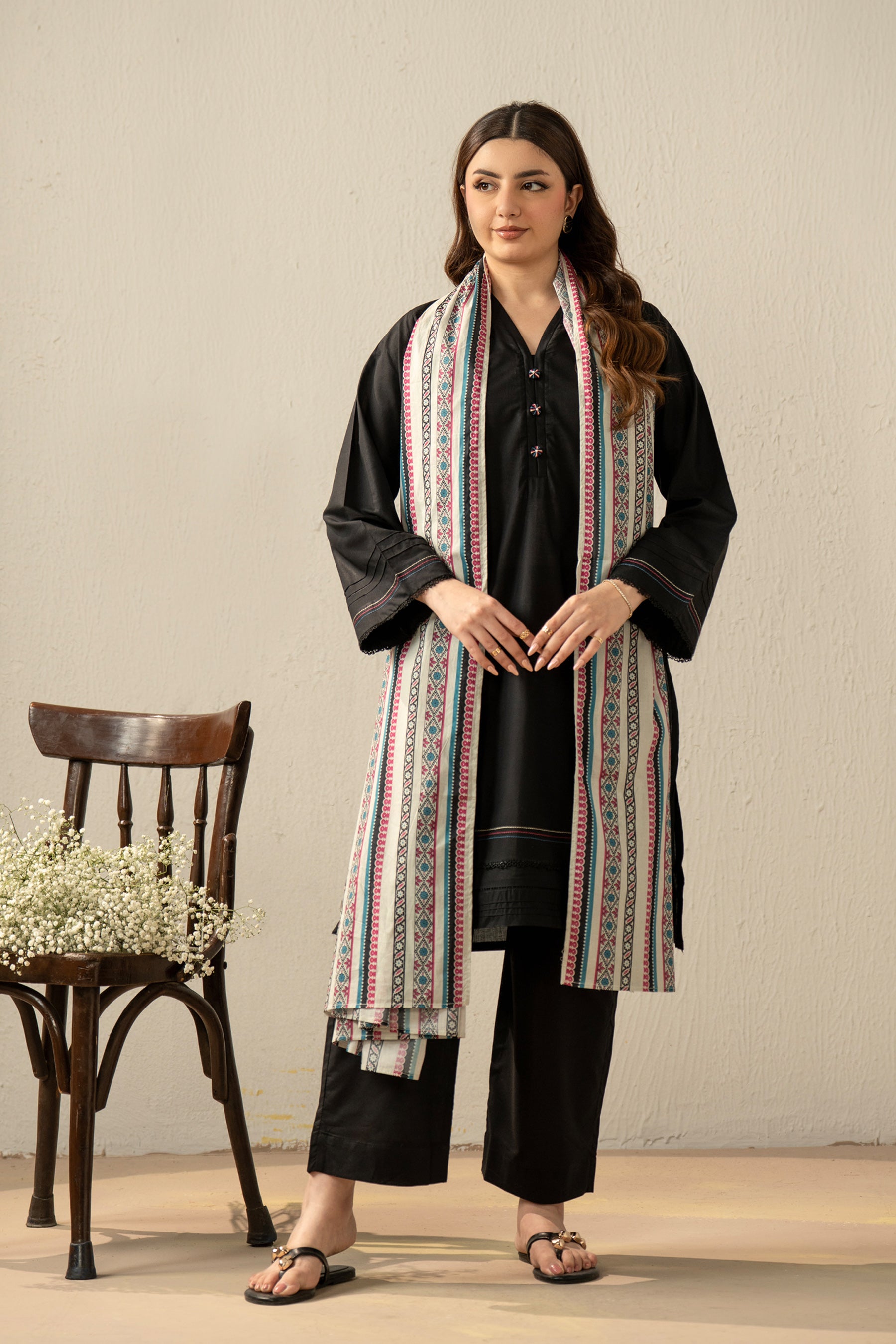 High-fashion stitched 3-piece black cambric suit with unique stylized cuts, matching dupatta, and trousers