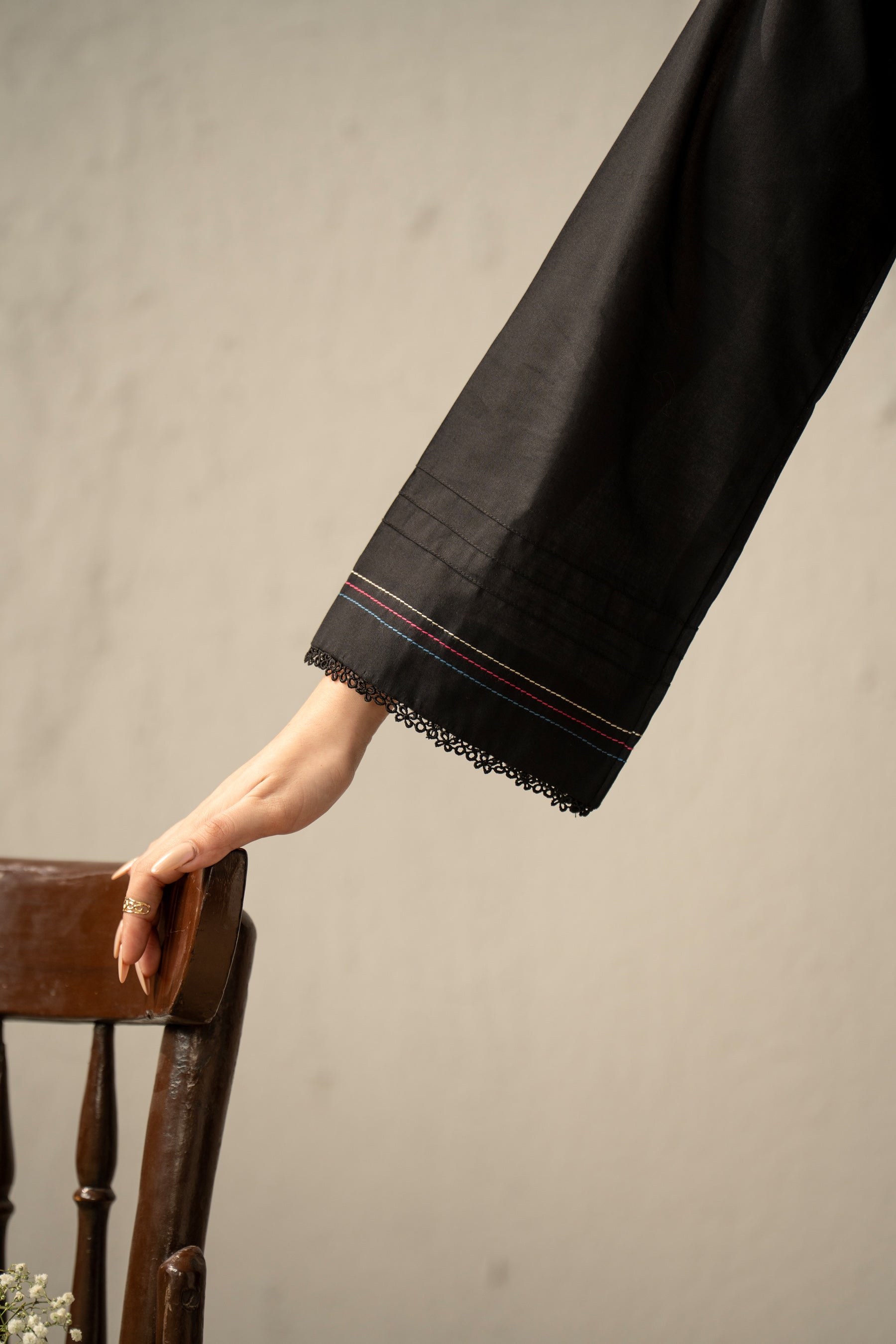 High-fashion stitched 3-piece black cambric suit with unique stylized cuts, matching dupatta, and trousers