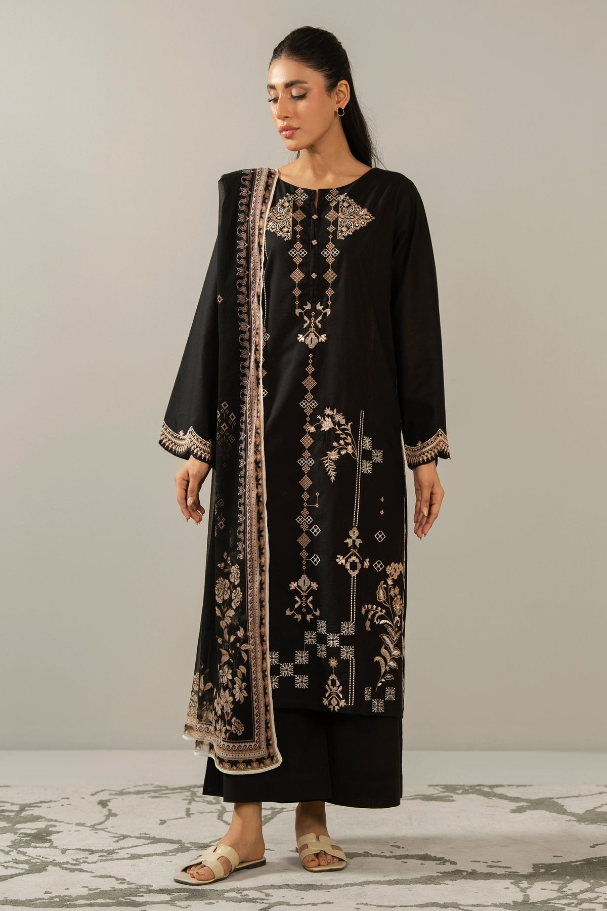 Premium stitched 3-piece black cambric suit displaying a mix of fine prints and embroidery, complete with a dupatta and matching trouser