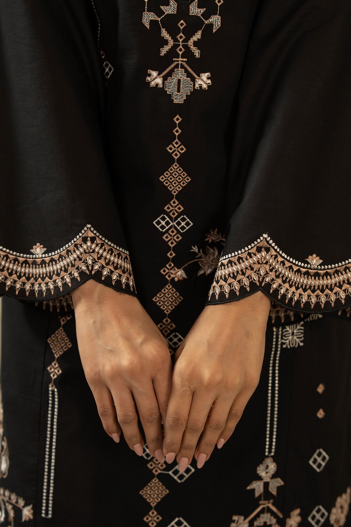Premium stitched 3-piece black cambric suit displaying a mix of fine prints and embroidery, complete with a dupatta and matching trouser