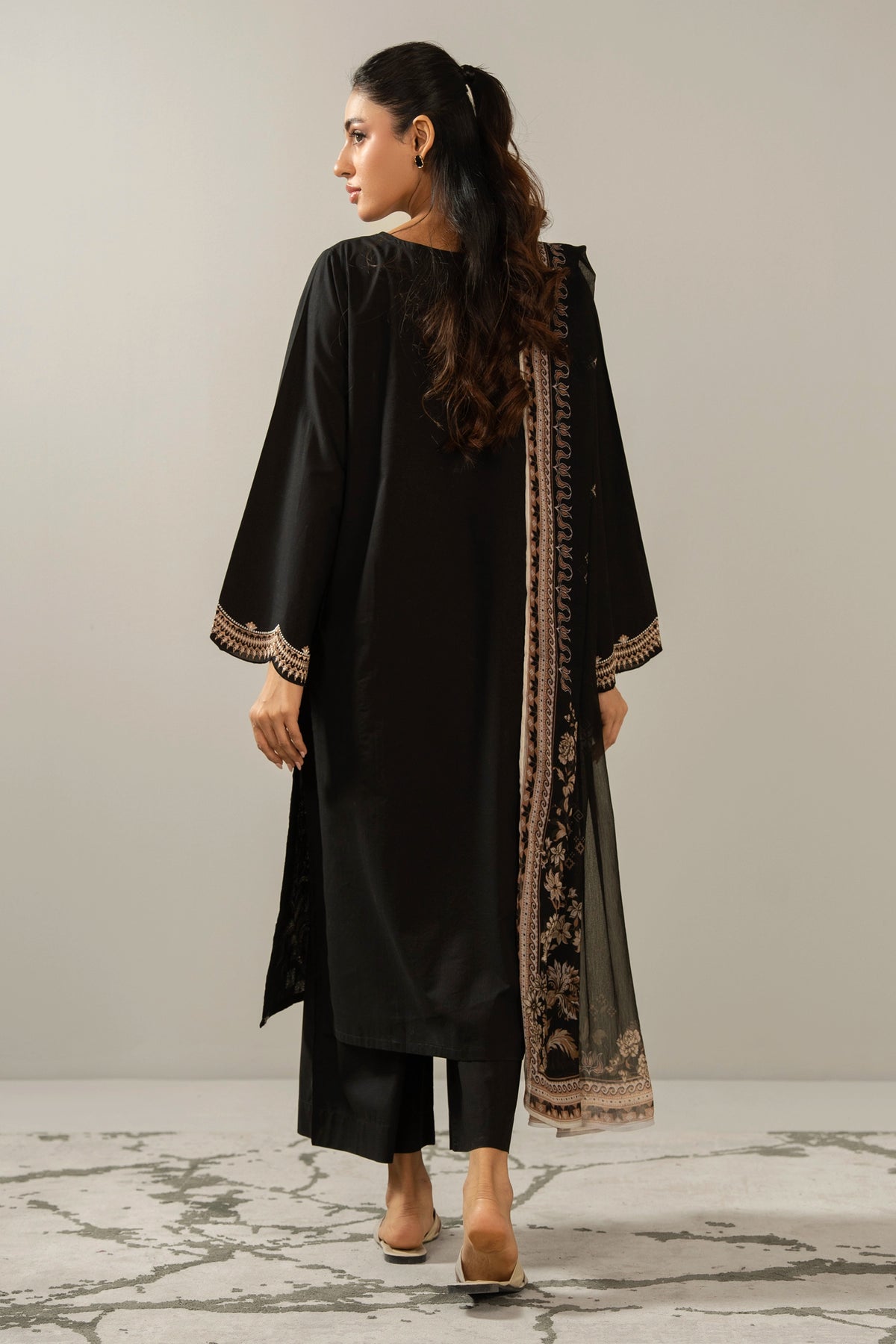 Premium stitched 3-piece black cambric suit displaying a mix of fine prints and embroidery, complete with a dupatta and matching trouser