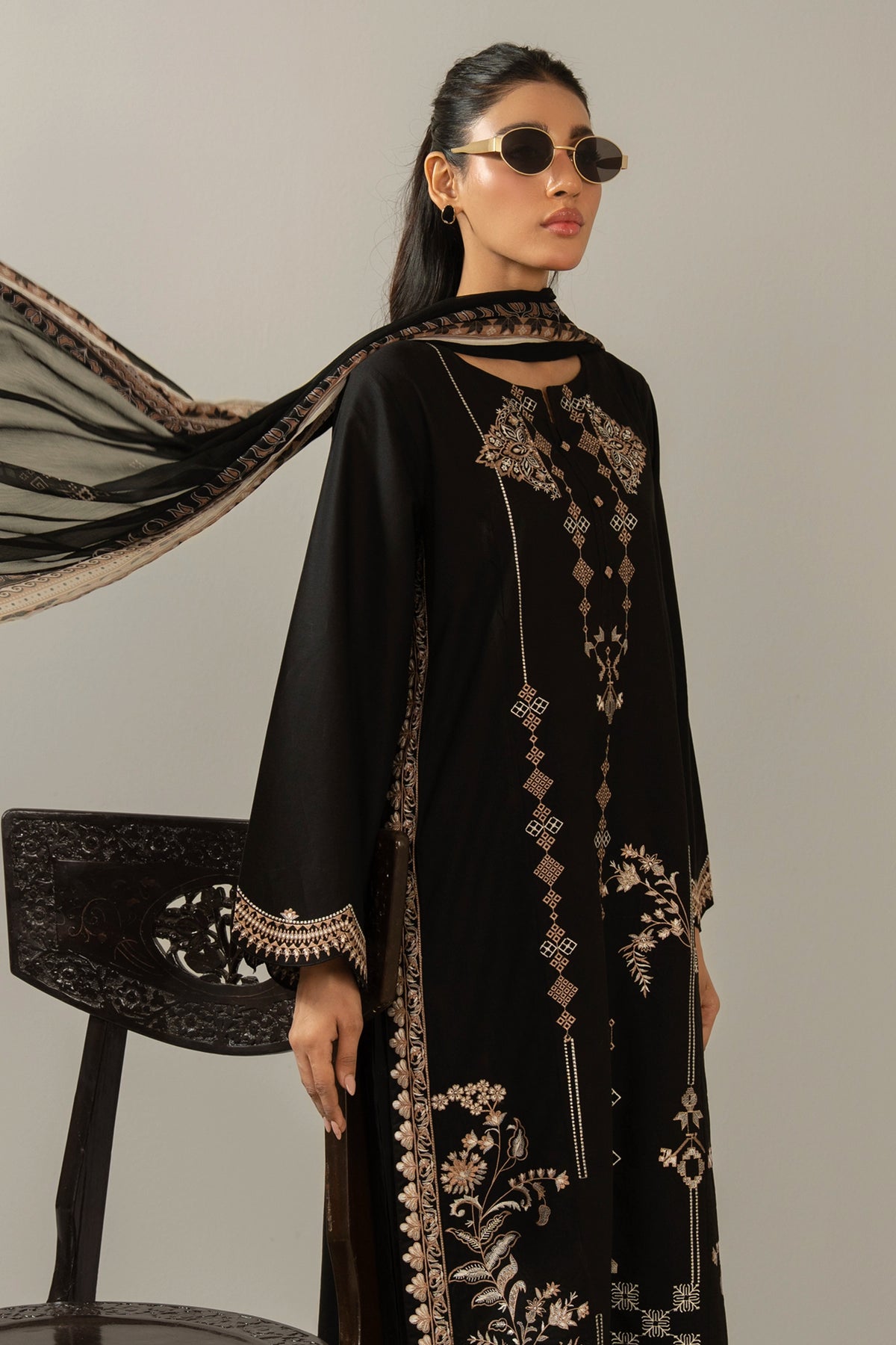 Premium stitched 3-piece black cambric suit displaying a mix of fine prints and embroidery, complete with a dupatta and matching trouser