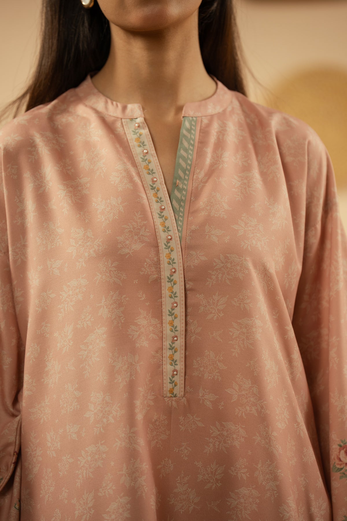Soft peach stitched 3-piece poly cambric suit featuring intricate floral print layouts, matching dupatta, and trousers