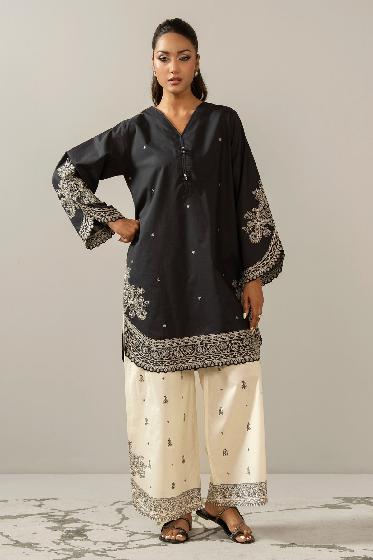 Sophisticated black embroidered cambric 2-piece stitched suit showcasing elegant neckline detailing and matching trousers