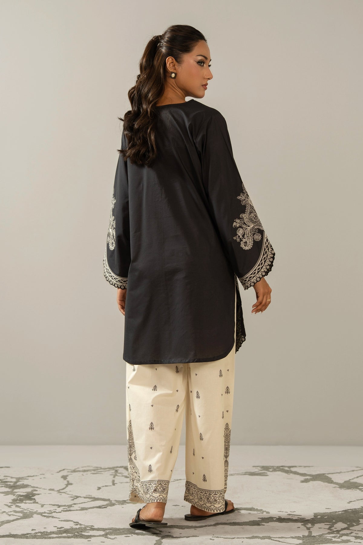 Sophisticated black embroidered cambric 2-piece stitched suit showcasing elegant neckline detailing and matching trousers