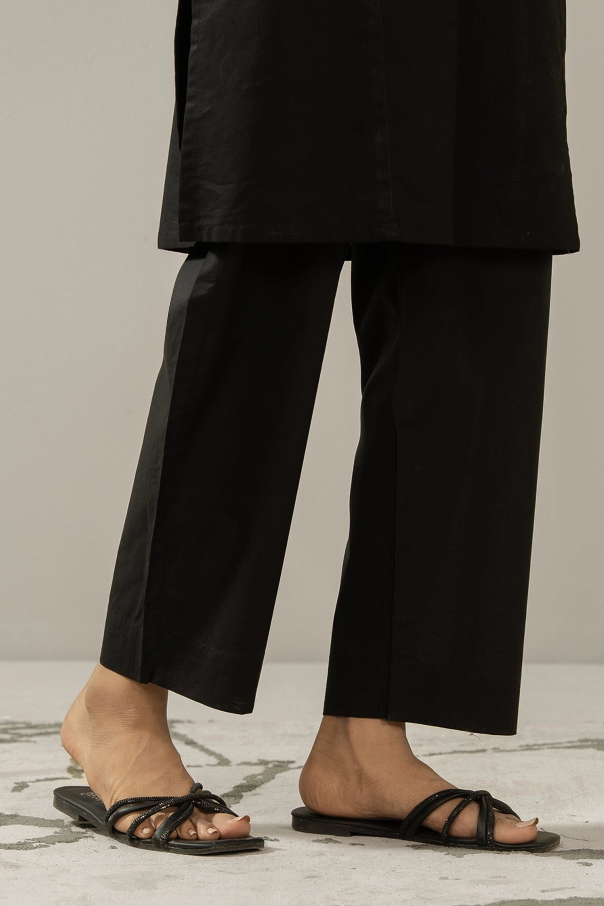 Trendy stylized black cambric straight pants with tailored details, perfect for versatile pairing